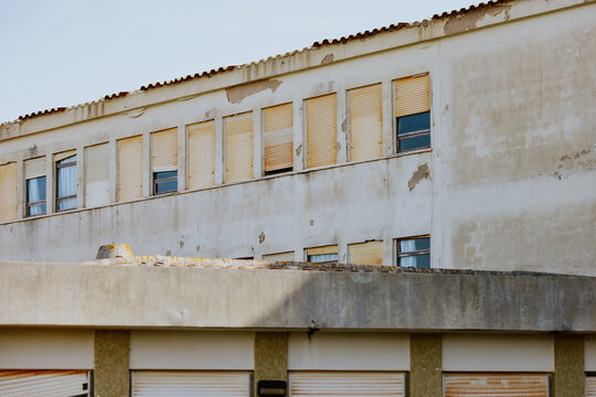 Weathered building with worn facade and closed windows