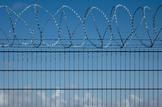 Barbed wire fence under a clear blue sky