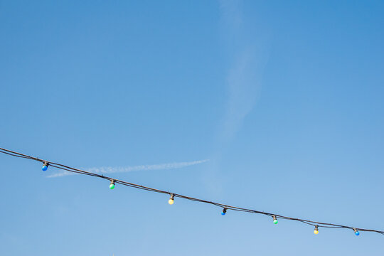 Colorful string lights against a clear blue sky