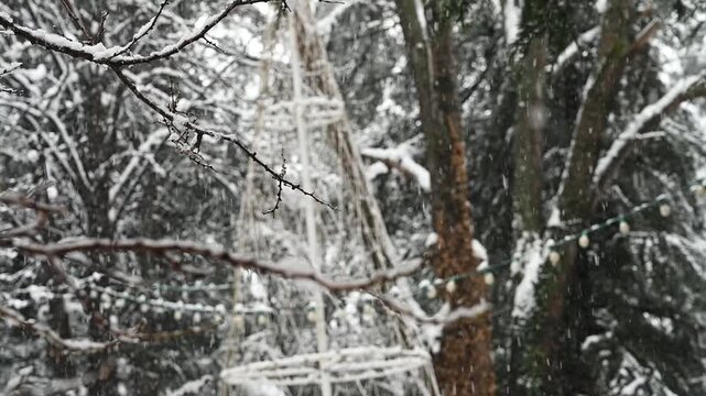 A person walks along a snow-dusted pathway in Saburtalo Park during a steady snowfall. The image captures the quiet, introspective mood of a winter walk in a Tbilisi neighborhood, with residential bui