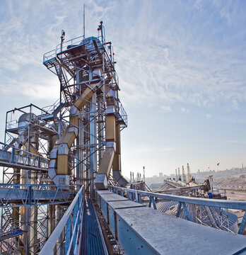 Industrial complex for grain processing with steel silos and conveyor systems.