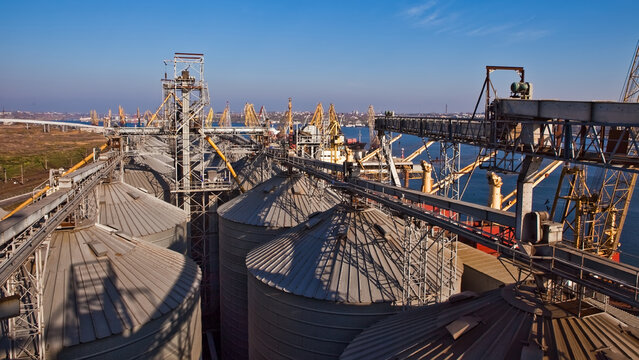 Industrial complex for grain processing with steel silos and conveyor systems.
