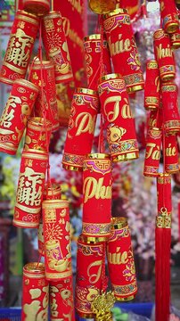 Colorful red and golden decorative elements sold on an vietnamese street market prior to the Tet holiday or Lunar new year in Vietnam, Asia. Vertical selective focus close up video.