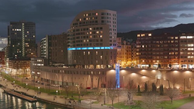 Night video from La Salve Bridge in Bilbao Spain showing the Nervion River promenade and modern and historic buildings.