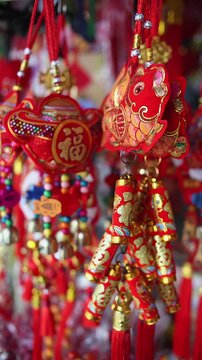 Colorful red and golden decorative elements sold on an vietnamese street market prior to the Tet holiday or Lunar new year in Vietnam, Asia. Vertical selective focus close up video.