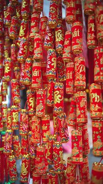 Colorful red and golden decorative elements sold on an vietnamese street market prior to the Tet holiday or Lunar new year in Vietnam, Asia. Vertical selective focus close up video.