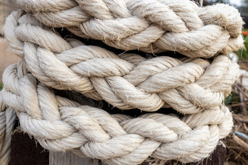 Fototapeta premium Thick white nautical rope coiled around a wooden post