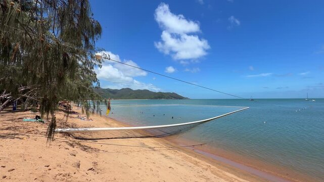 View from the beach of a shark and stinger protection net installed in shallow tropical waters at Horseshoe Bay, Magnetic Island, Queensland, Australia, showing a designated safe swimming area.