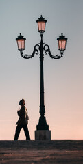 silhouette of a man with earphones next to a vintage lantern