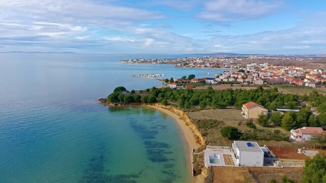 Aerial footage of sand beach near Zaton, Croatia, eroded limestone cliffs and blue adriatic sea.