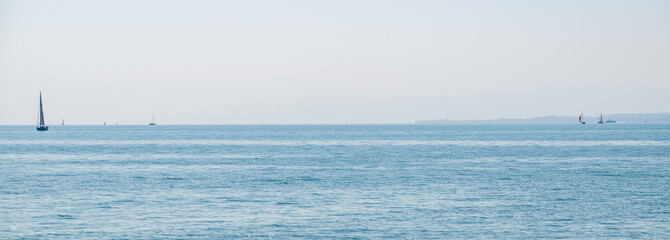 Obraz premium Sailboats dotting lake constance on summer day