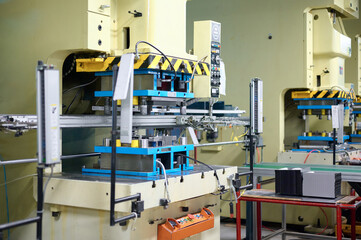 Cold metal stamping and pressing production line operates efficiently in a modern factory setting during daytime hours