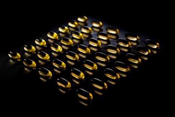 Omega tablets arranged on a black background with backlighting