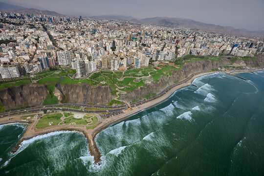 stunning aerial perspective captures the dramatic meeting of urban sophistication and natural grandeur along Lima&rsquo;s famous Costa Verde. The image showcases the sheer, rugged cliffs 