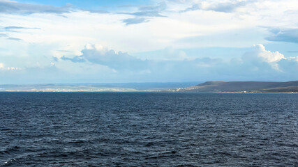 Obraz premium Calm Coastal Seascape with Blue Sky and Distant Shore