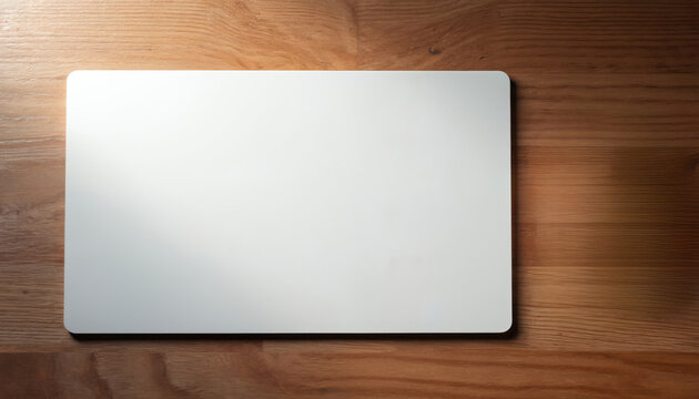 White rectangular mouse pad sits on textured wooden desk surface from above. Blank mat offers ample space for custom designs, logos, or branding visuals.