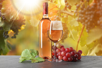 Fototapeta premium Wine and fresh grapes on table. Glass and bottle in vineyard