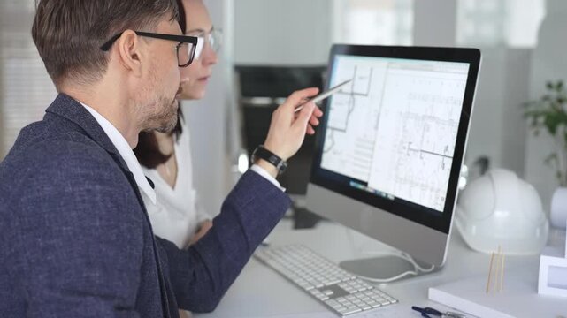 Architecture and engineering team collaborating on project blueprints using computer aided design software in an office. Business and architecture concept