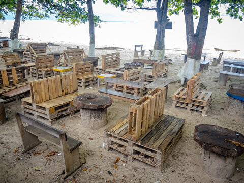 Beach bar with chairs built from wooden pallets and tables made from palm tree trunks