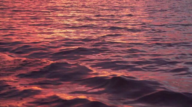 A slow-motion view of a tranquil lake during a vibrant sunset