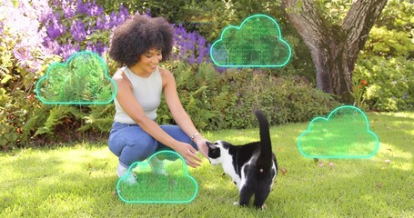Crouching woman reaching for b and w cat in yard, with tank top, jeans, watch, holographic clouds © vectorfusionart