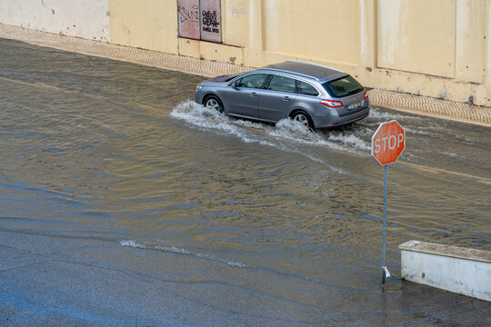 Cars passing through the flooded road after the storm. Barreiro, Portugal.