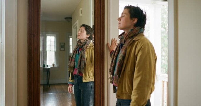 Woman gazing at reflection in mirror indoors