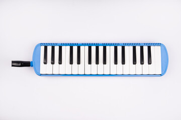 Fototapeta premium Blue 32-key melodica with mouthpiece. High-quality portable wind instrument for beginners and students. Crisp sound, durable plastic body, easy-to-play design.