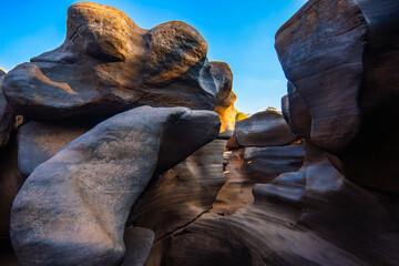 Natural rock formation with smooth curves and potholes under blue sky during sunset light Lei Dan Stone Field Thailand