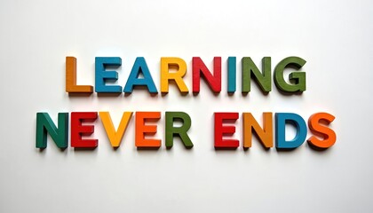 Fototapeta premium Colorful wooden letters spell Learning Never Ends on white background. Concept of lifelong knowledge acquisition and continuous self improvement.