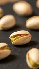 Obraz premium Close-up macro shot of pistachios with their shells slightly open revealing the green nut inside