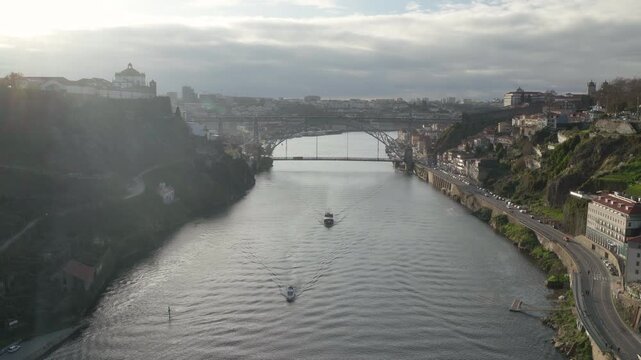 Porto bridge perspective of the iconic iron bridge with a small boat passing.