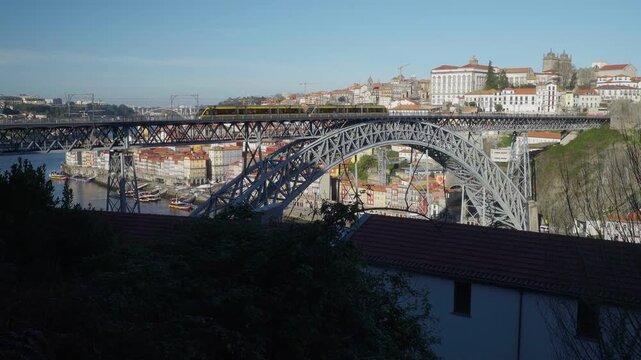 Wide view of the Dom Luis I Bridge and Ribeira waterfront from across the Douro.