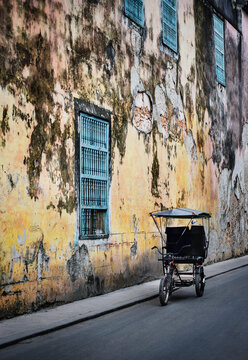 Traditional rickshaw in front of an old building in Havana, Cuba