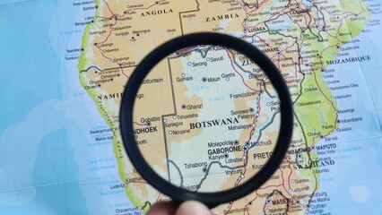 View of Botswana, on a geographic map of Africa, seen using a magnifying glass © PinkyEn