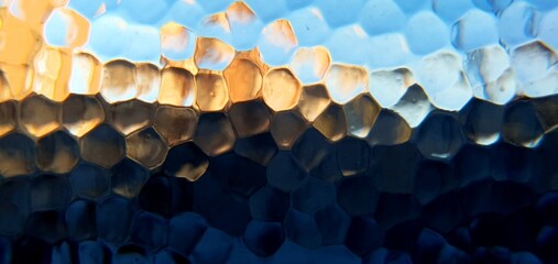 Obraz premium Abstract frosted glass with techno futurism light refraction. Modern honeycomb geometric pattern and blue gold bokeh distortion, ideal for futuristic technology and web backgrounds