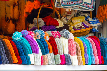 Warm colorful woollen hats sold on market outdoor during winter