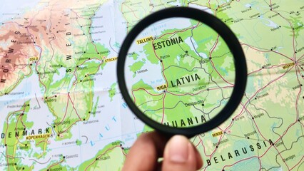 View of Latvia, officially the Republic of Latvia, is a country in the Baltic region of Northern Europe, on a geographical map of Europe, seen using a magnifying glass © PinkyEn