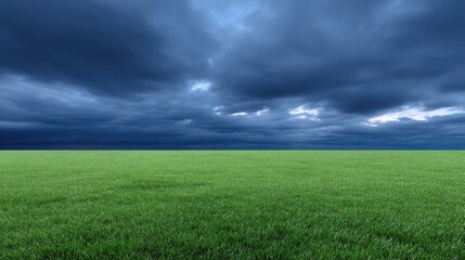Fototapeta premium Wide Open Green Field Under Dramatic Dark Clouds Creating an Atmosphere of Anticipation and Natural Beauty Showcasing Dynamic Landscape Elements