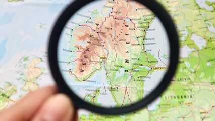 View of Sweden, formally the Kingdom of Sweden, is a Nordic country located on the Scandinavian Peninsula in Northern Europe, on a geographical map of Europe, seen using a magnifying glass