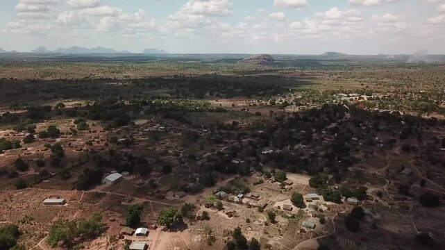 Aerial panorama of rural northern Mozambique (Nampula region), showing scattered villages and fields across dry savanna woodland, with isolated rocky hills (inselberg &ldquo;island mountains&rdquo;) on the