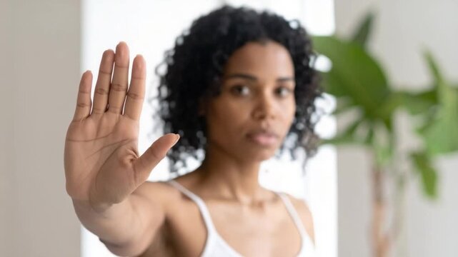 Young African American woman showing stop gesture with open palm