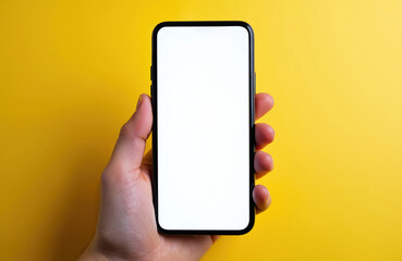 Hand holds modern smartphone with blank white screen against bright yellow background. Device ready for use showing copy space for content. Tech gadget for communication.