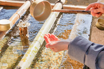 神社の手水舎で手を清める様子