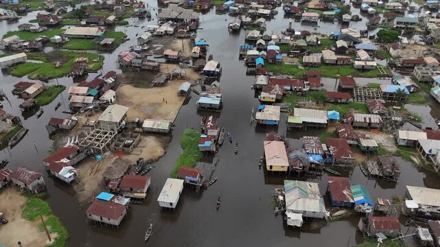 A high-angle drone shot providing a detailed look at the traditional stilt architecture and the intricate network of water paths in Ganvie, West Africa