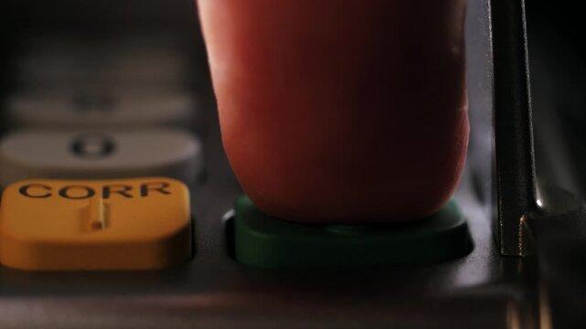 Close up of finger entering a four digit pin code and pressing OK