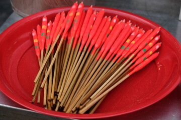 A large pile of red fishing floats with bamboo sticks on a red plate © Thanakrit