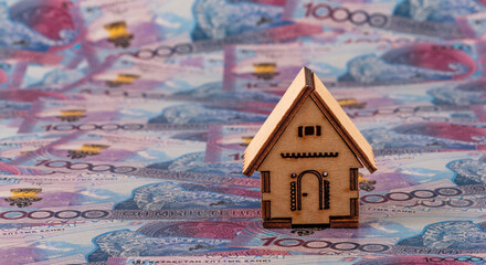 A conceptual story about real estate in Kazakhstan featuring a charming wooden house and 10,000 Kazakhstani tenge banknotes. © Max Zolotukhin