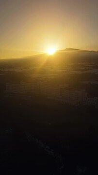 Aerial portrait rotating in front of a hotel, Mt Hallasan background, sunset in Jeju, South Korea