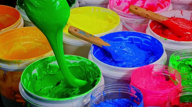 Scoop of Green Plastisol Ink from a White Bottle for Fabric Prints and more, showcasing thick textured paint and wooden spatulas. The image captures creativity artistic expression